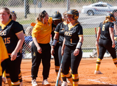 Softball player Abby Jolly watches while Angel Pearsall bats