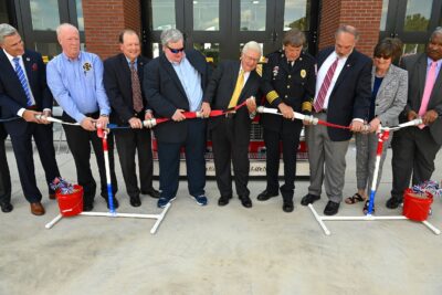 A line of people hold a segment fire hose ready to uncouple it.