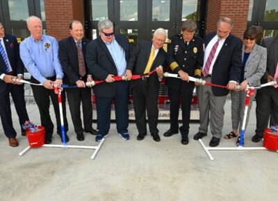 A line of people hold a segment fire hose ready to uncouple it.