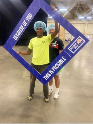 Two students pose with a handheld photo frame.