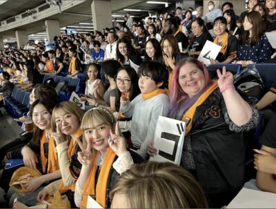 A group of people pose for the camera in the stands at a baseball game.