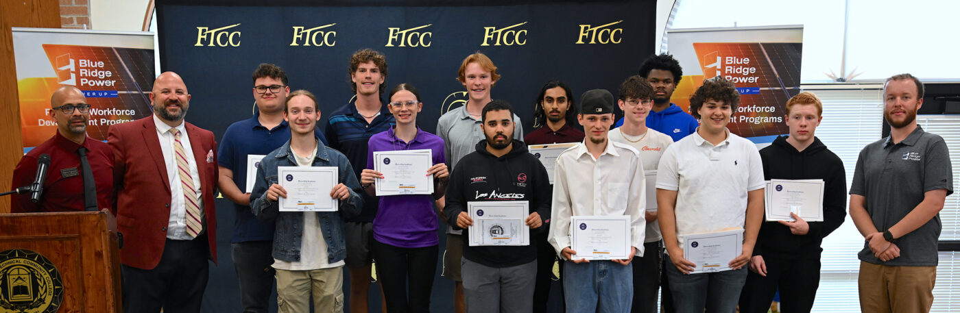 Students holding certificates stand in a group for a photo.