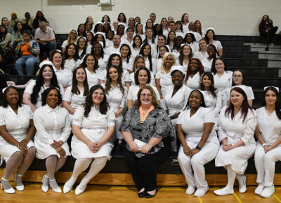 A group of nursing students sits together on gym bleachers.