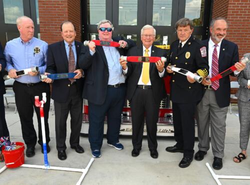 A close-up of some of the people who uncoupled the hose holding up their fire hose segments.