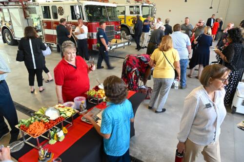 A crowd photo of people enjoying refreshments inside the garage bay.